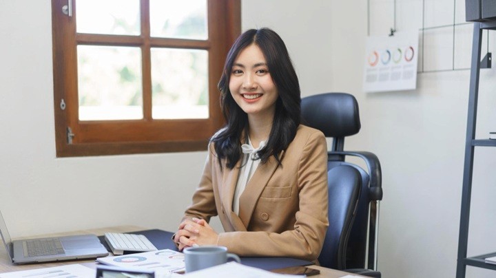 Illustration of a company secretary working at a computer with documents and schedules, representing administrative and compliance work