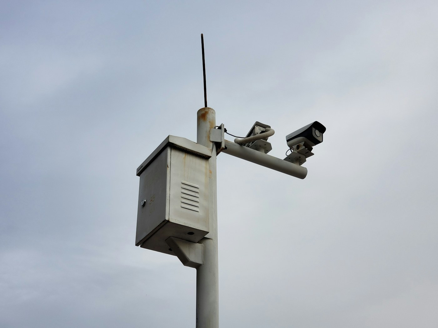weather station instruments on a pole against a grey sky