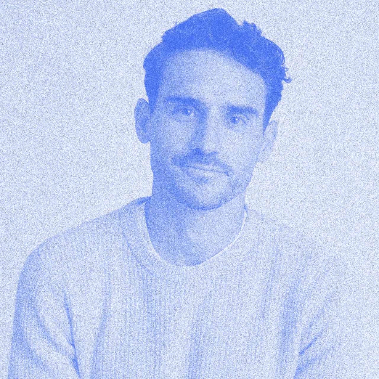 Smiling man with dark hair in blue-toned portrait