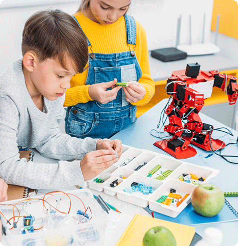 children building and programming a robotics project during a STEM enrichment activity at school