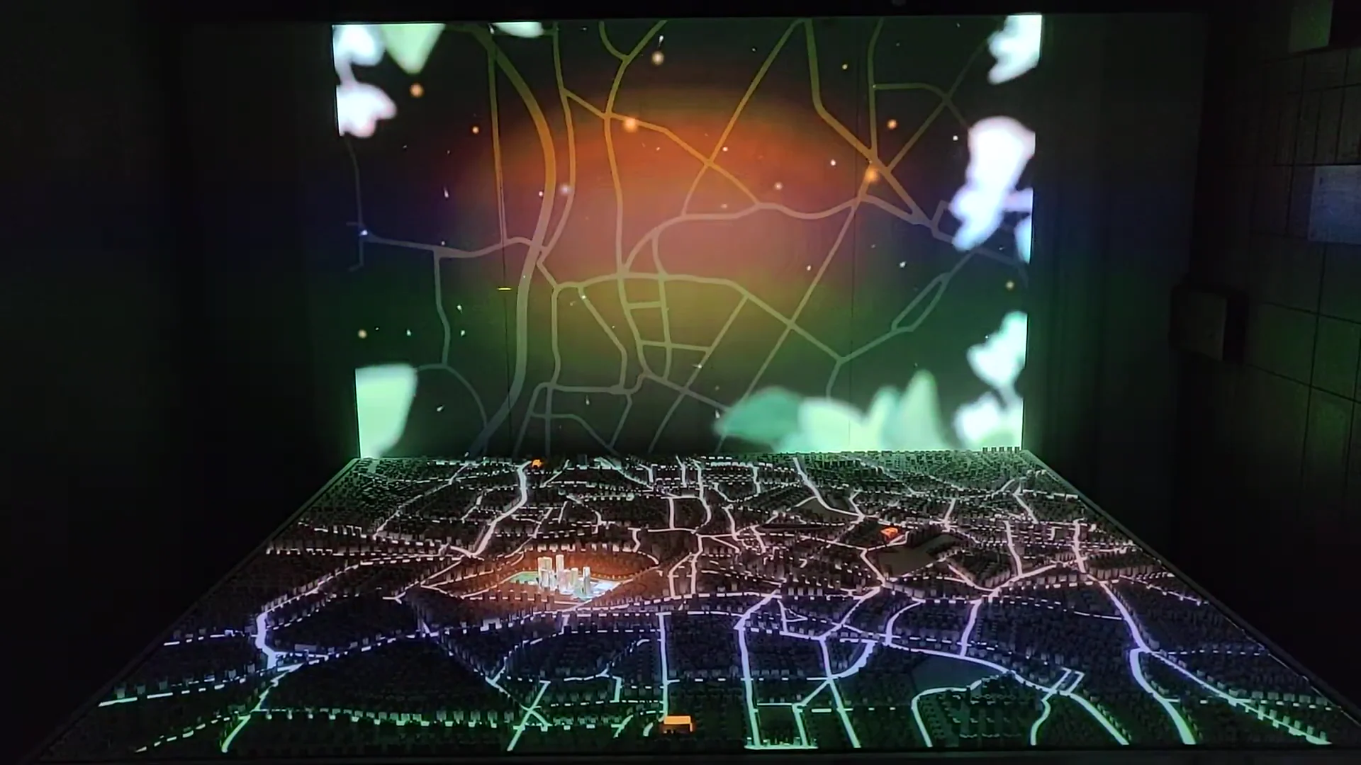 Projected routes across a physical scale model with a coordinated map on the front display