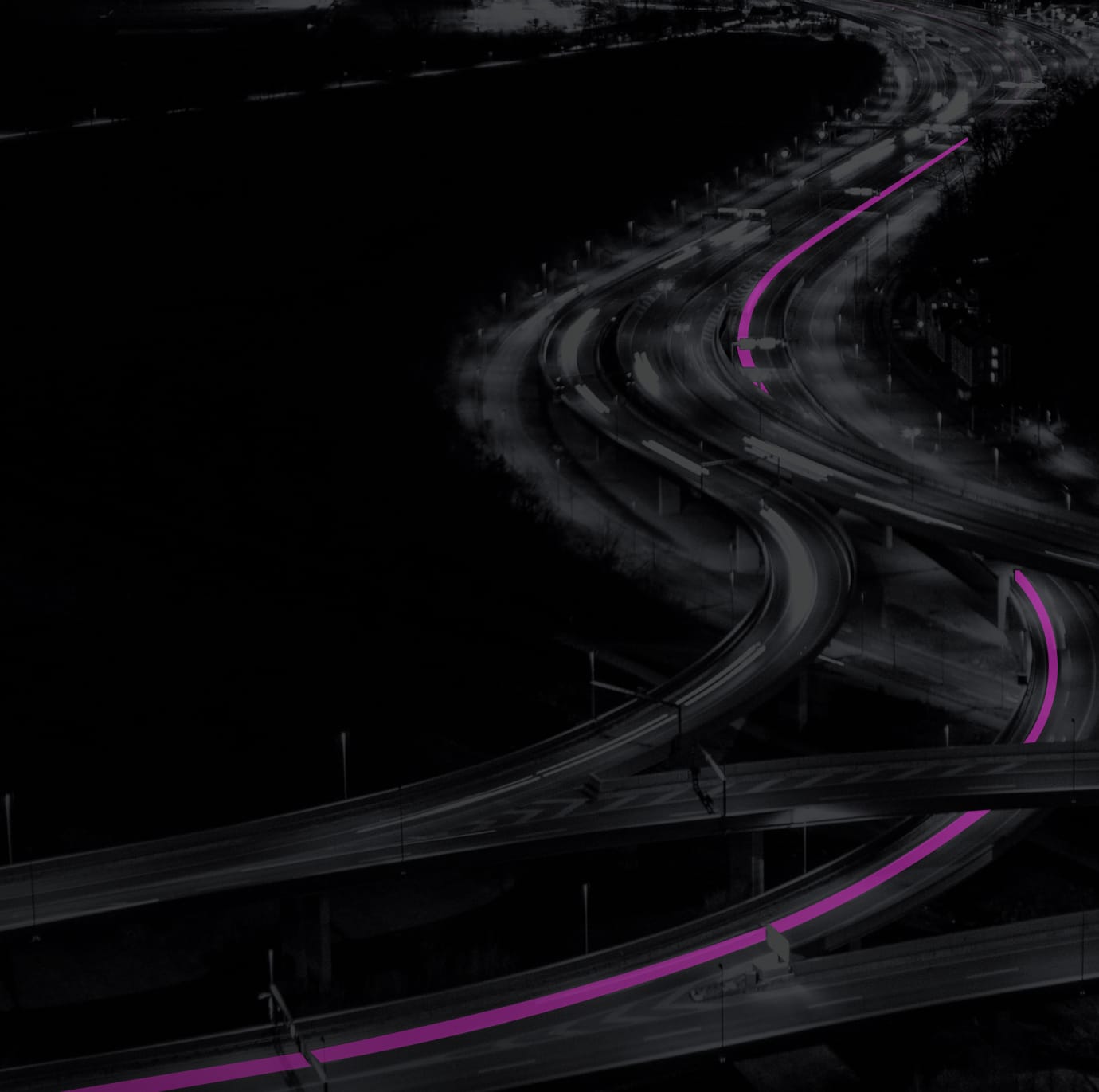 A busy highway at night with a route marked in pink