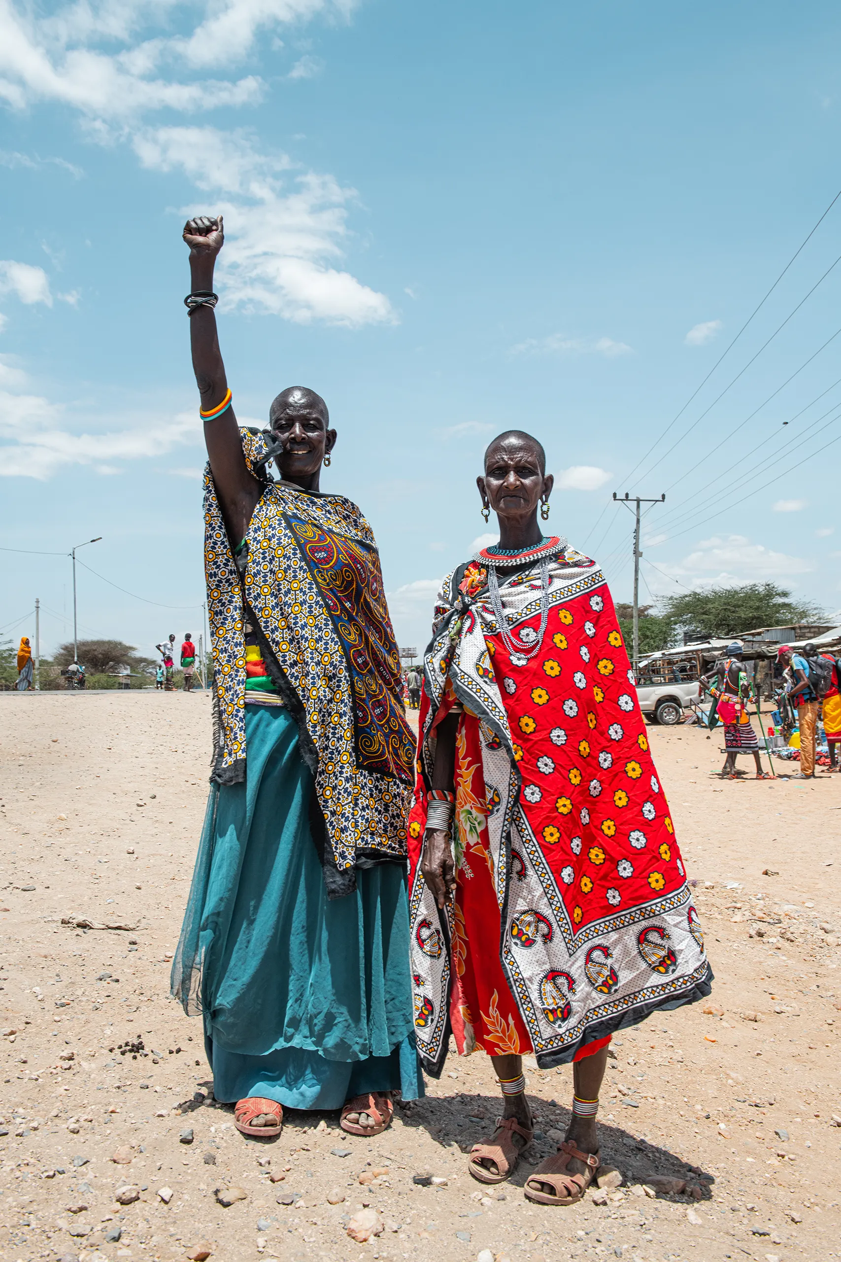 A medium shot of two Samburu women in vibrant traditional clothing and beaded necklaces.