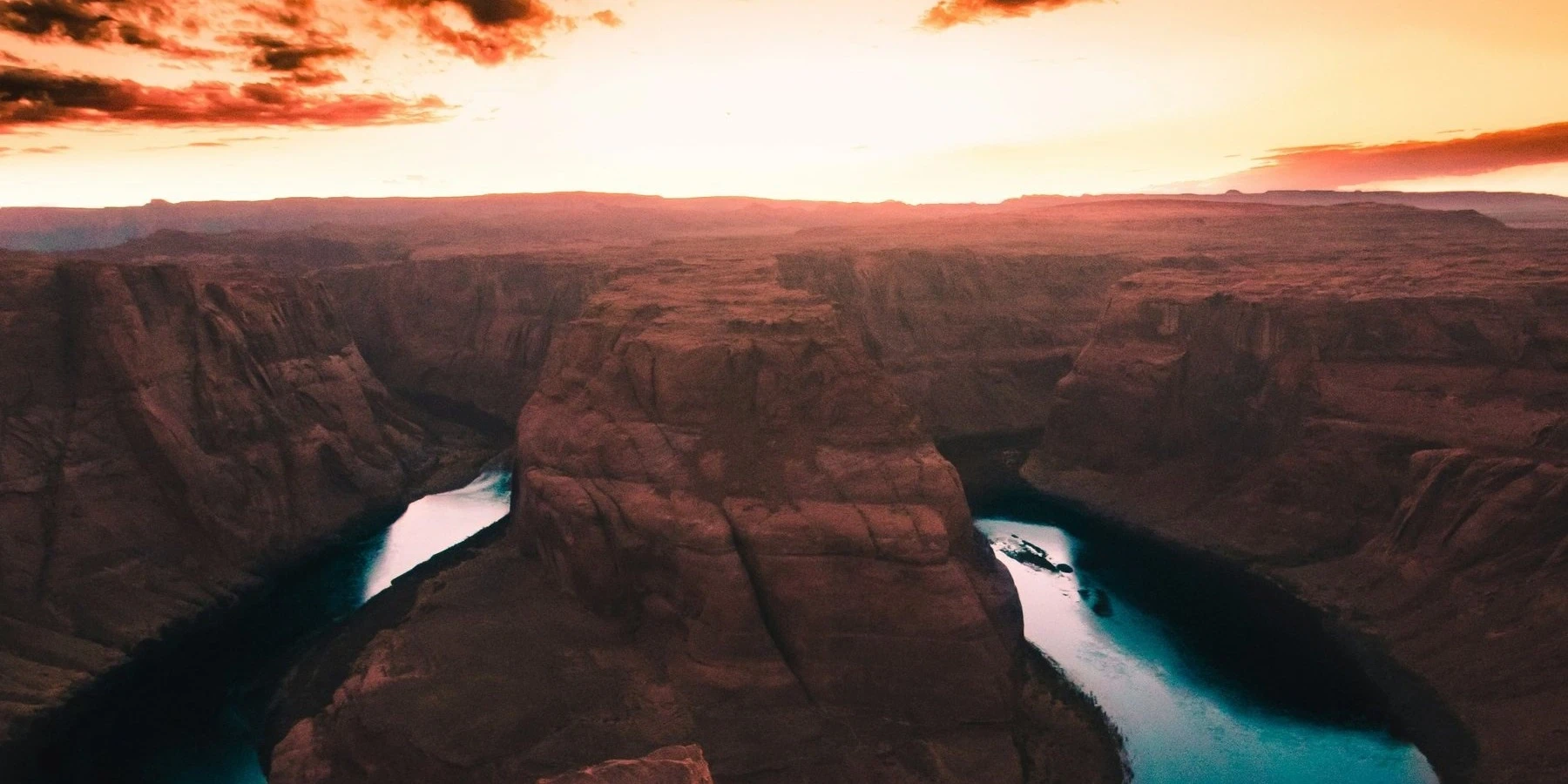 Horseshoe Bend at sunset, the Colorado River curving around a red sandstone butte near Page, Arizona