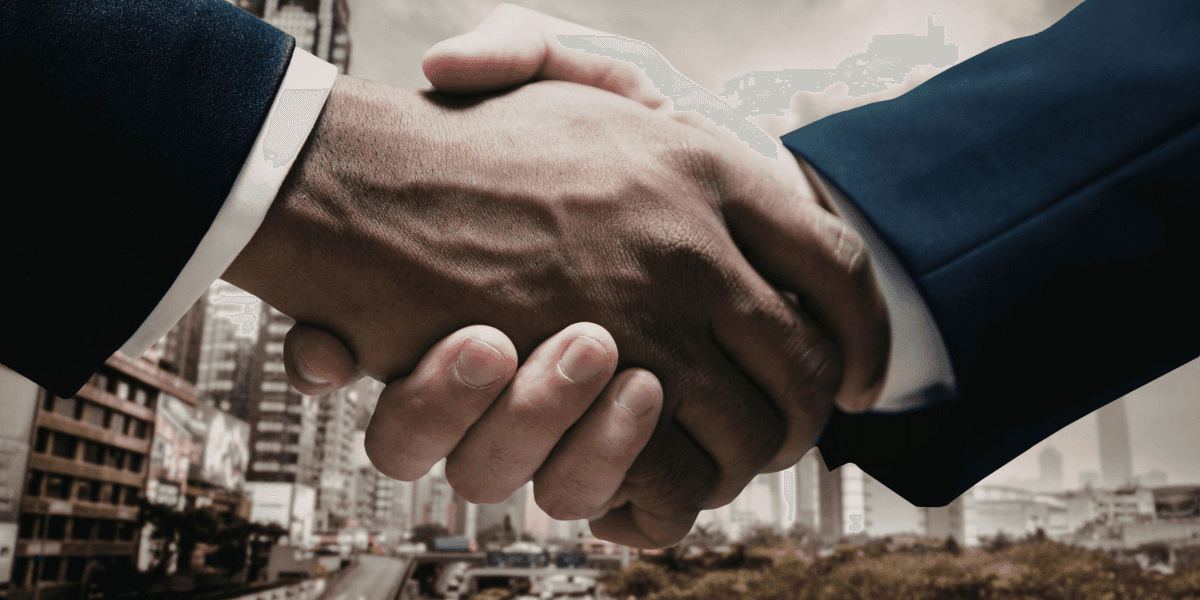 Business professionals shaking hands in a city setting, symbolizing partnership, trust, and modern business collaboration.