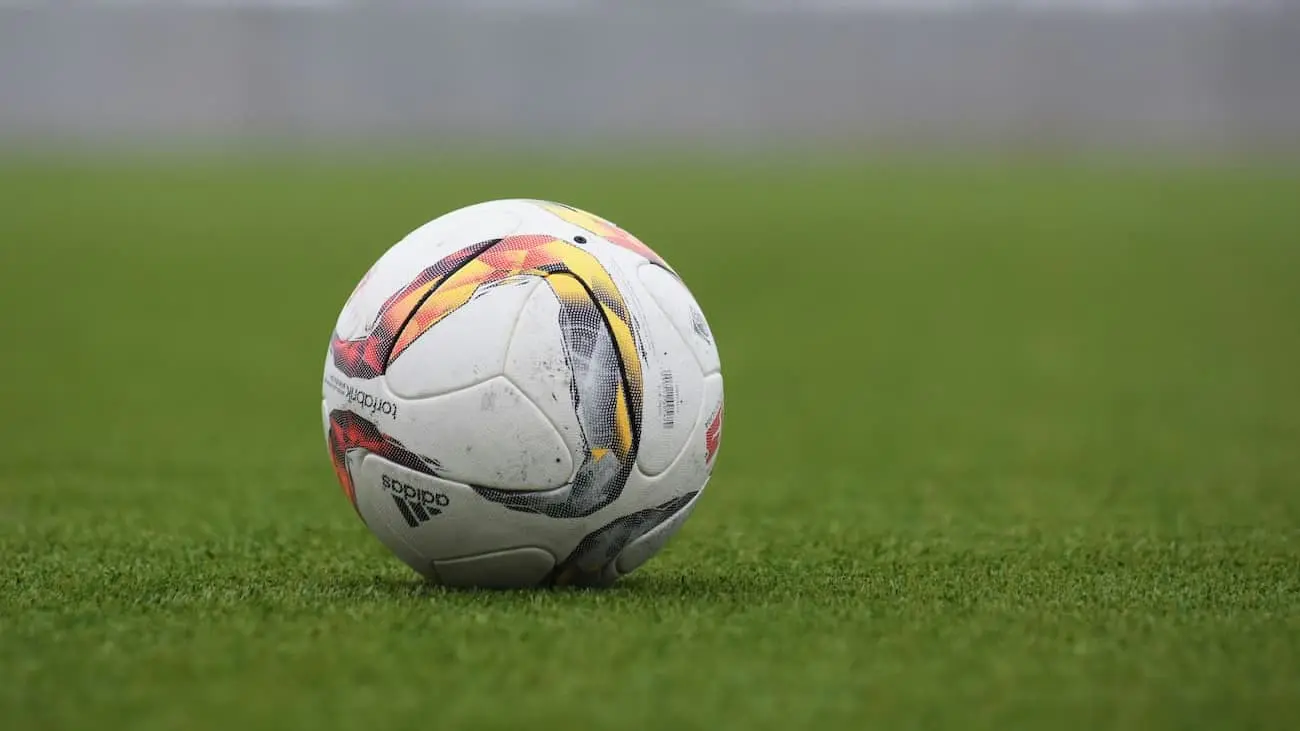 Close-up of a football on a grassy field, symbolising the forward-thinking training philosophy and strategic vision of the German Football Association (DFB), aimed at fostering talent and enhancing the quality of the game in Germany.