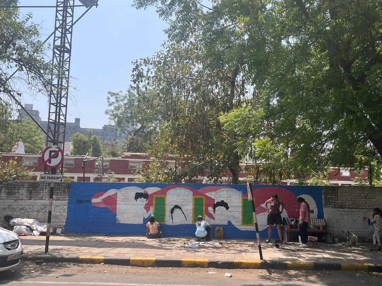 Modern home office setup with a monitor, ergonomic chair, keyboard, and indoor plants near a window with blinds.