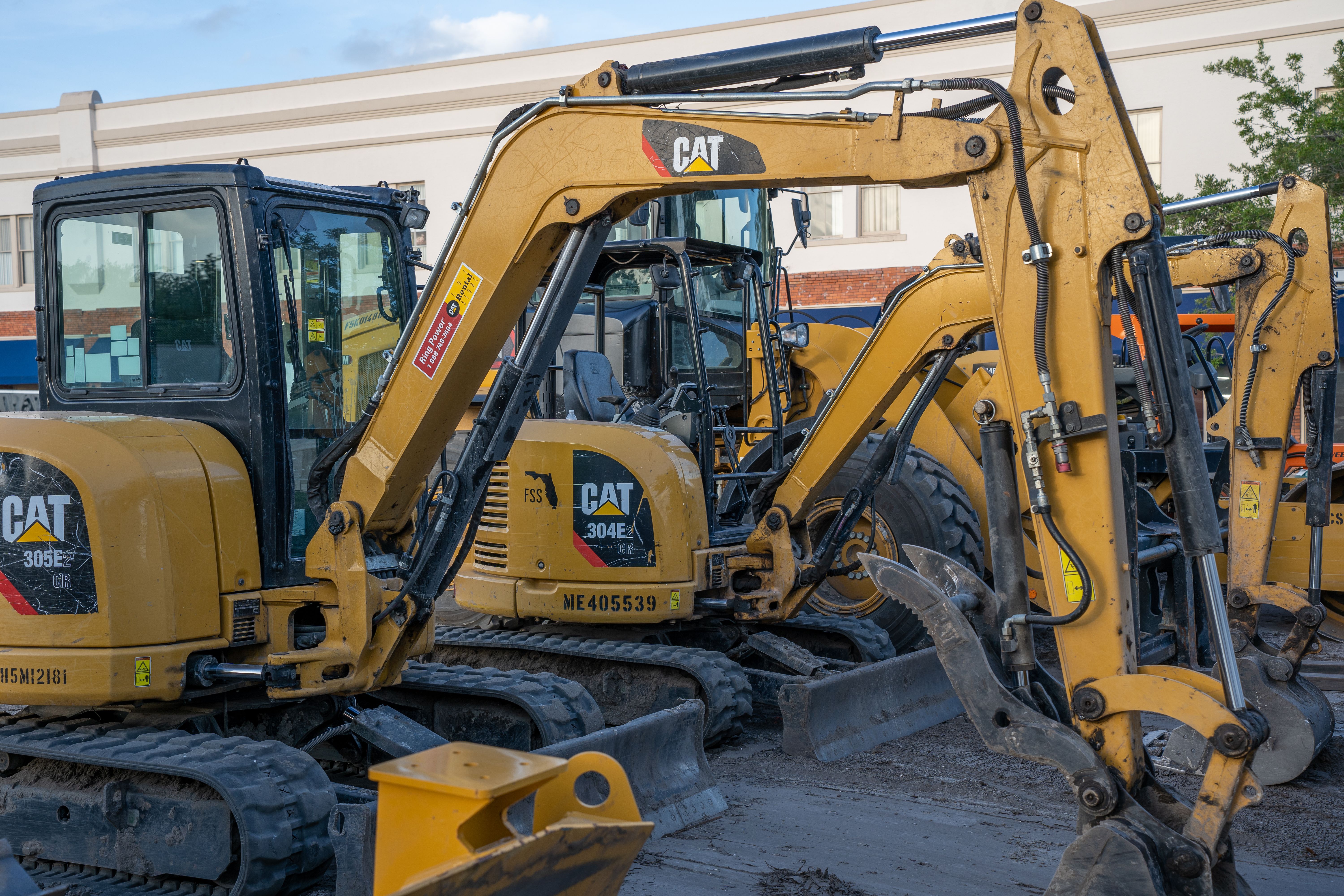 Row of CAT mini excavators parked in a hire yard