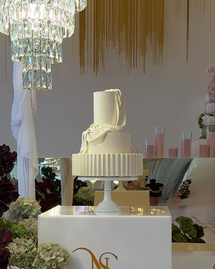 three tire wedding cake with velvet finish and cascading draping details.