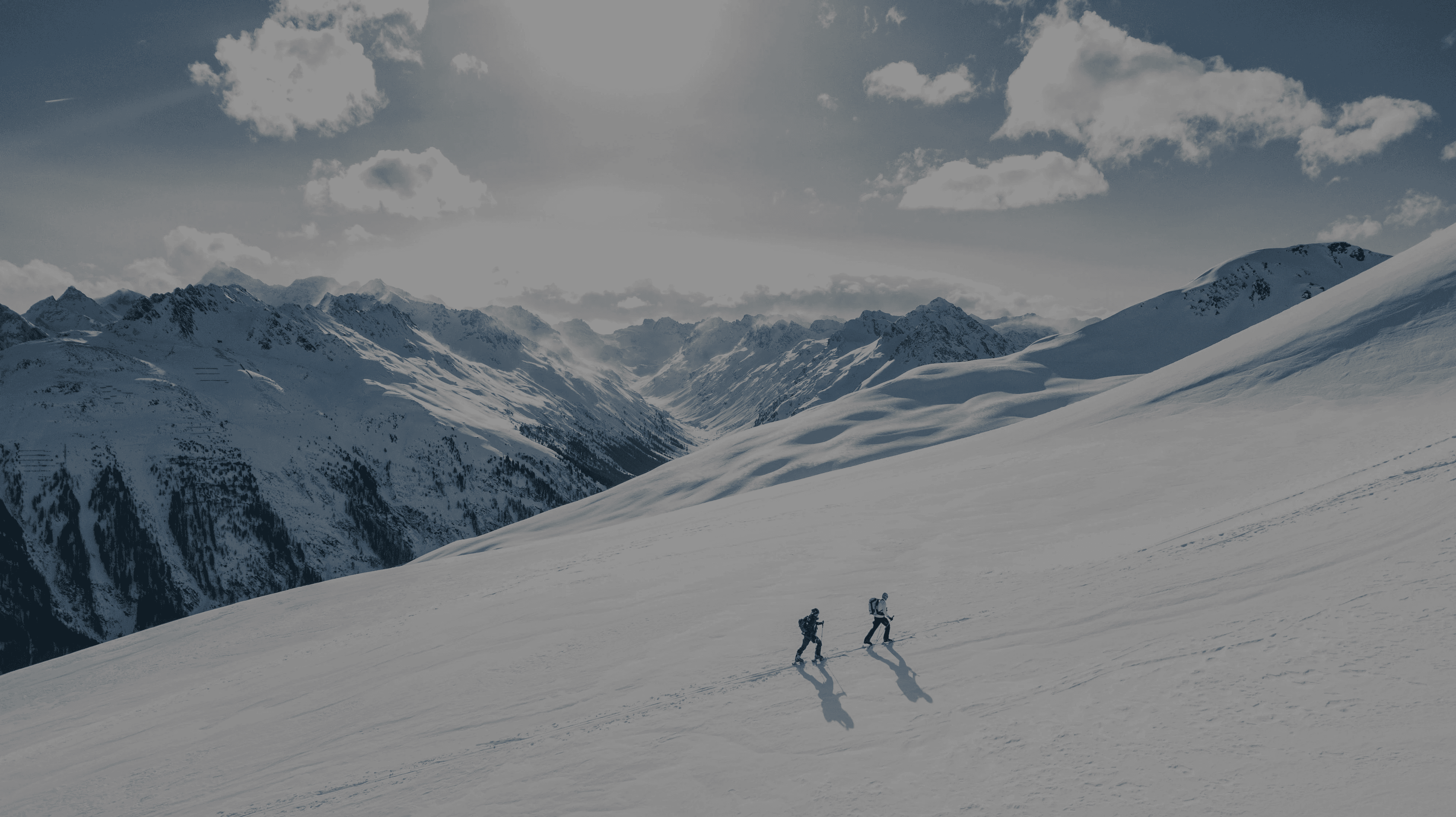 Two skiers crossing a snowy mountain landscape, illustrating how Linqa adapts as your life evolves.