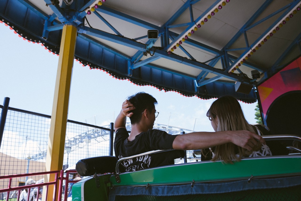 A couple holding each other on a roller coaster