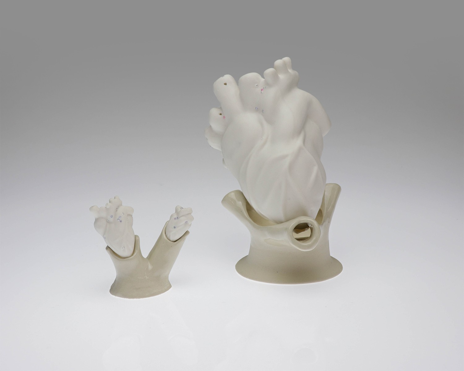 Individual view of a unique ceramic heart from Perfect Imperfection series by Yuxin Song. Highlighting cracks with cubic zirconia and mica powder. Light-up sculpture made with resin, 2022.