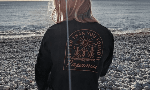 Man in a sporty jacket and light shorts walking across a football field, confidently pulling on his collar.