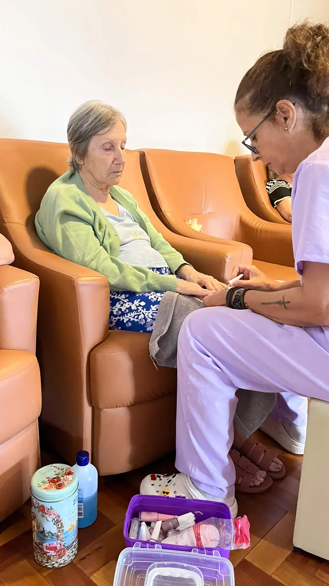 Cuidadora pintando às unhas de uma residente - Residencial Geriátrico Nova Era