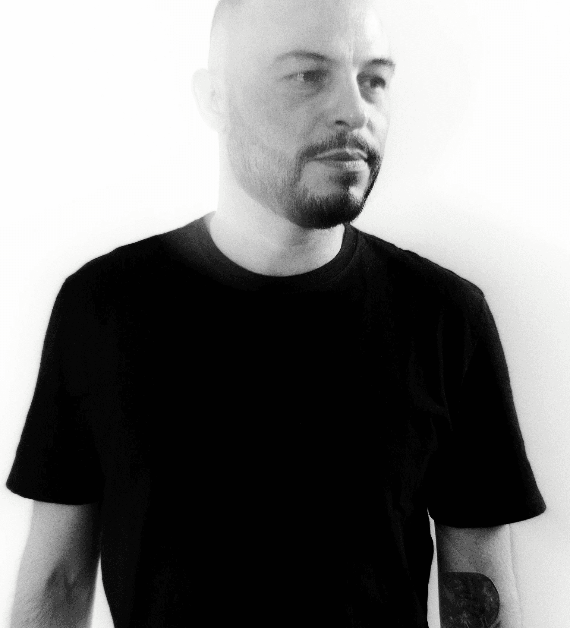 My portrait wearing a black shirt. looking to the left, over a white background