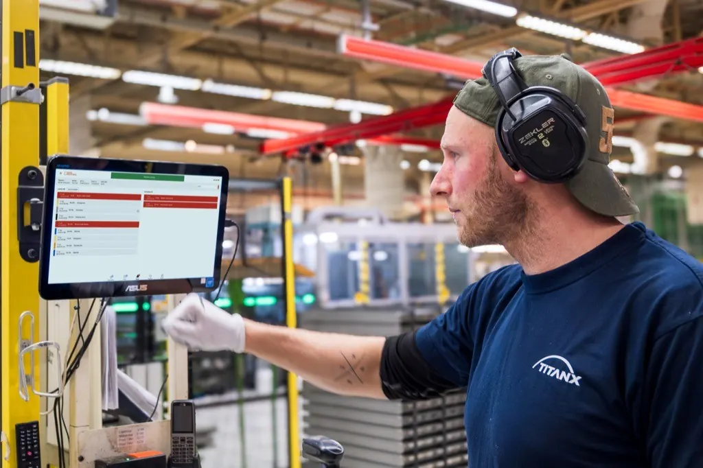 Operatör registrerar stopporsaker på en pekskärm vid produktionslinjen i TitanX fabrik