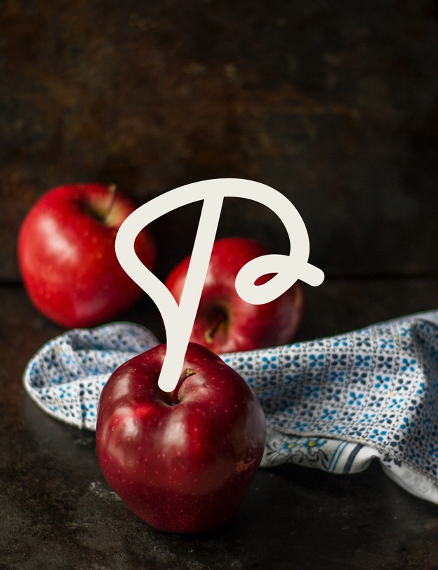 Logo secondaire de Proxi : P, sur une composition photo avec des pommes.