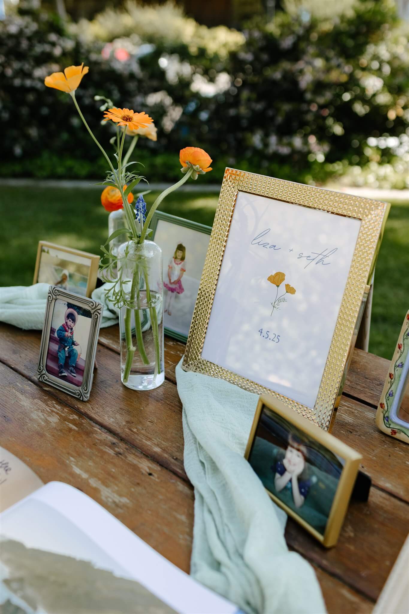 Welcome sign with hand drawn poppies next to a vase of ranunculus on the welcome table at a wedding
