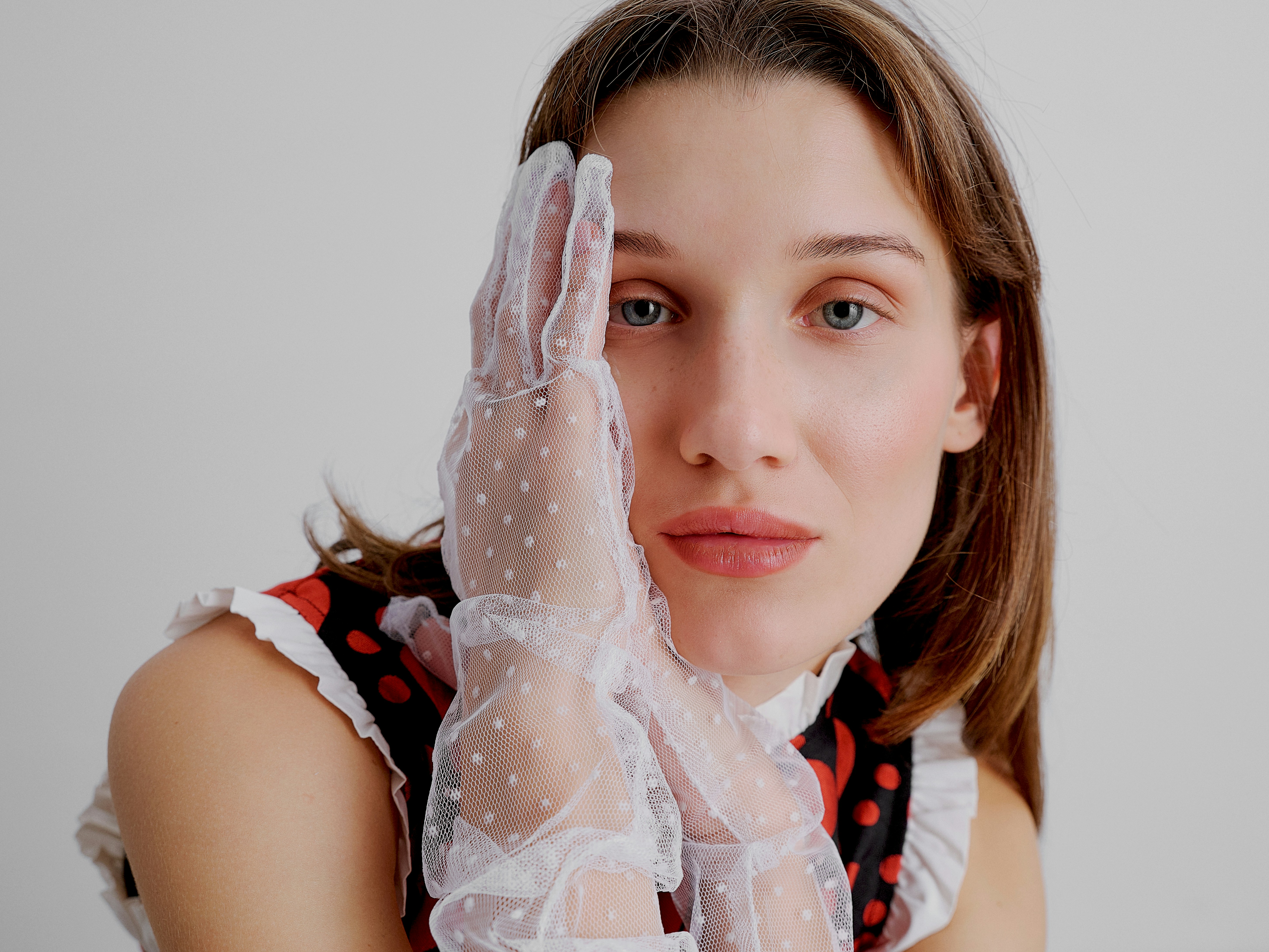woman in polka dot dress and sheer gloves