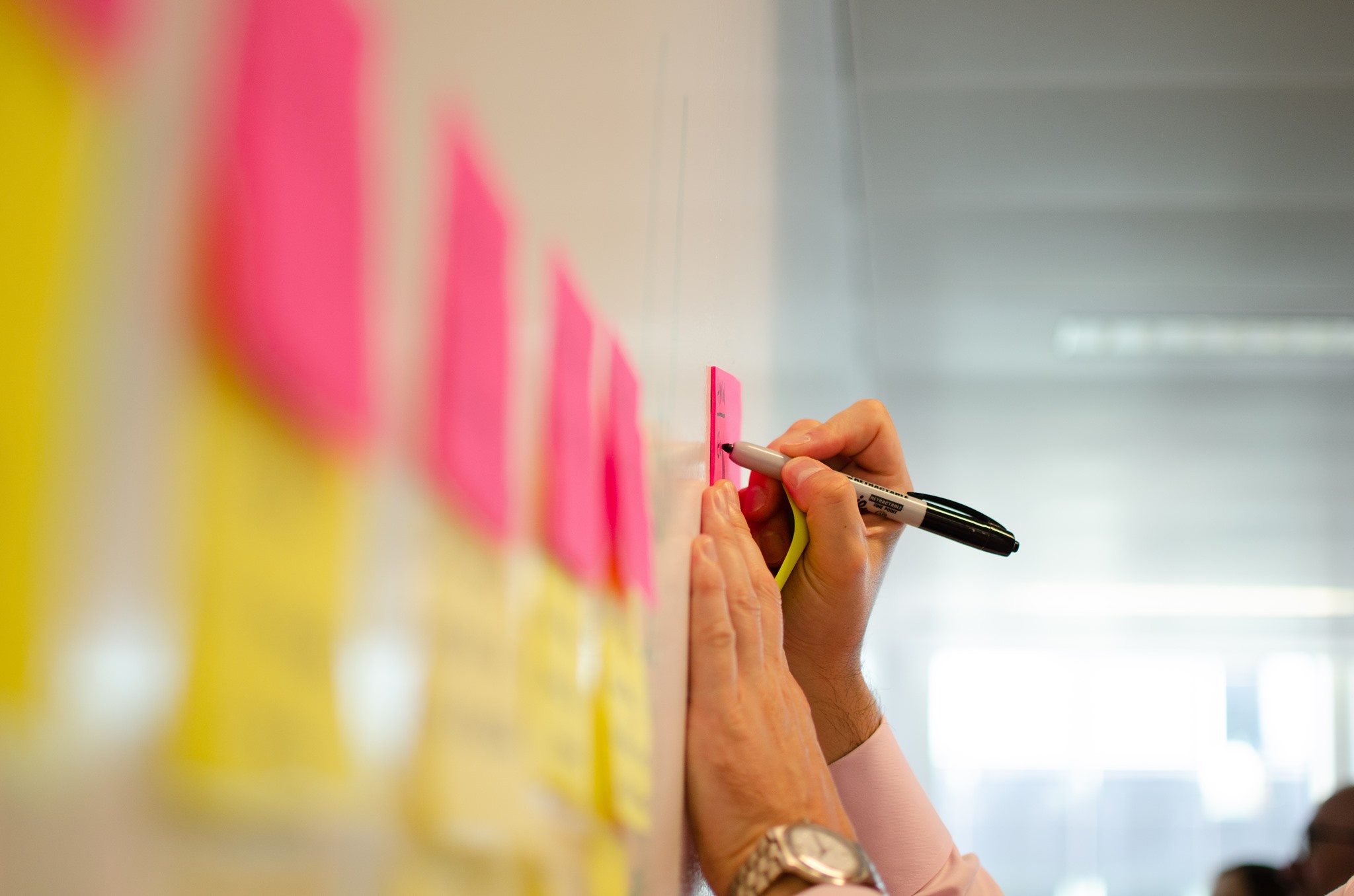 A woman stands in an office, with social media icons emerging from her laptop, symbolizing digital connectivity and engagement.