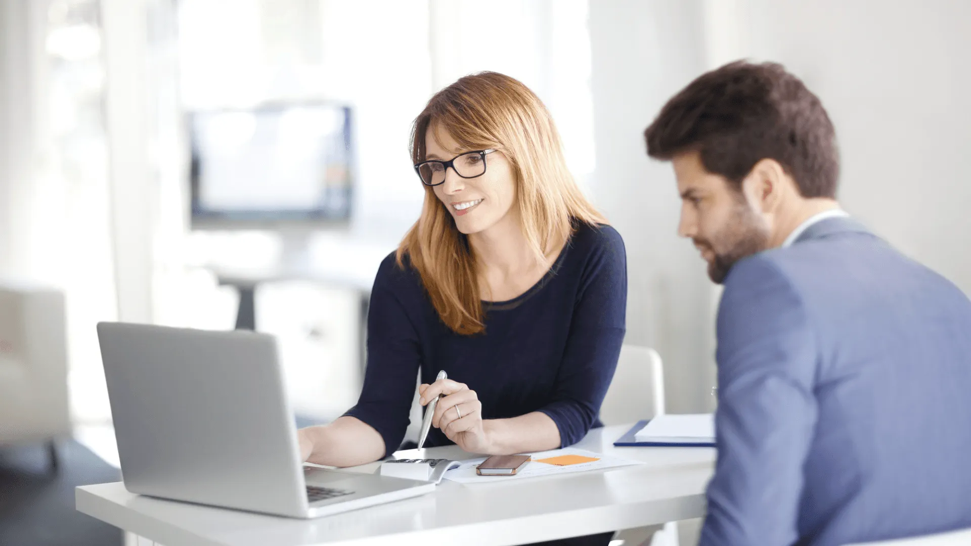 Two people working together on a laptop