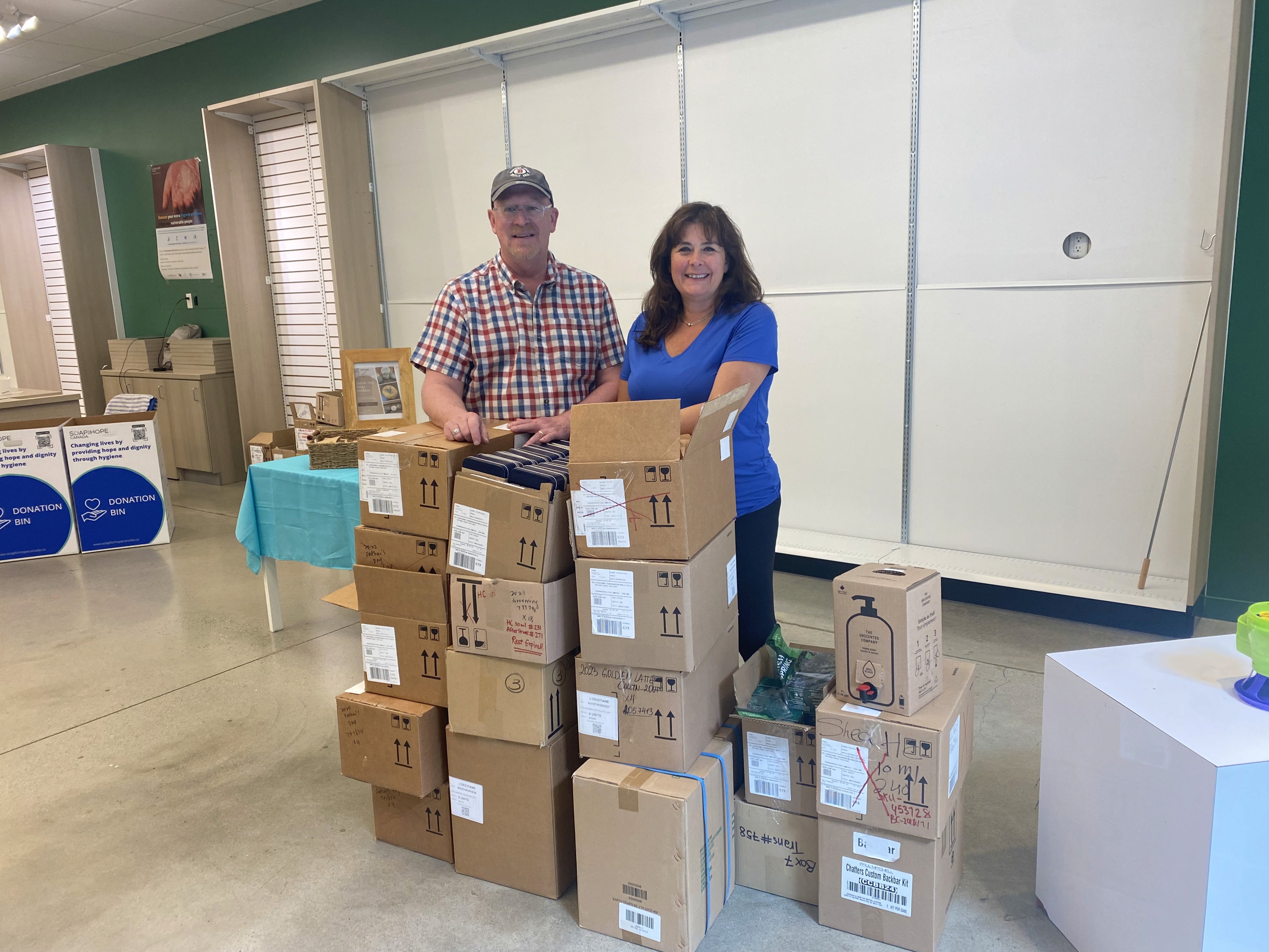 Image for Soap for Hope Canada's CEO with another person with boxes if donated products