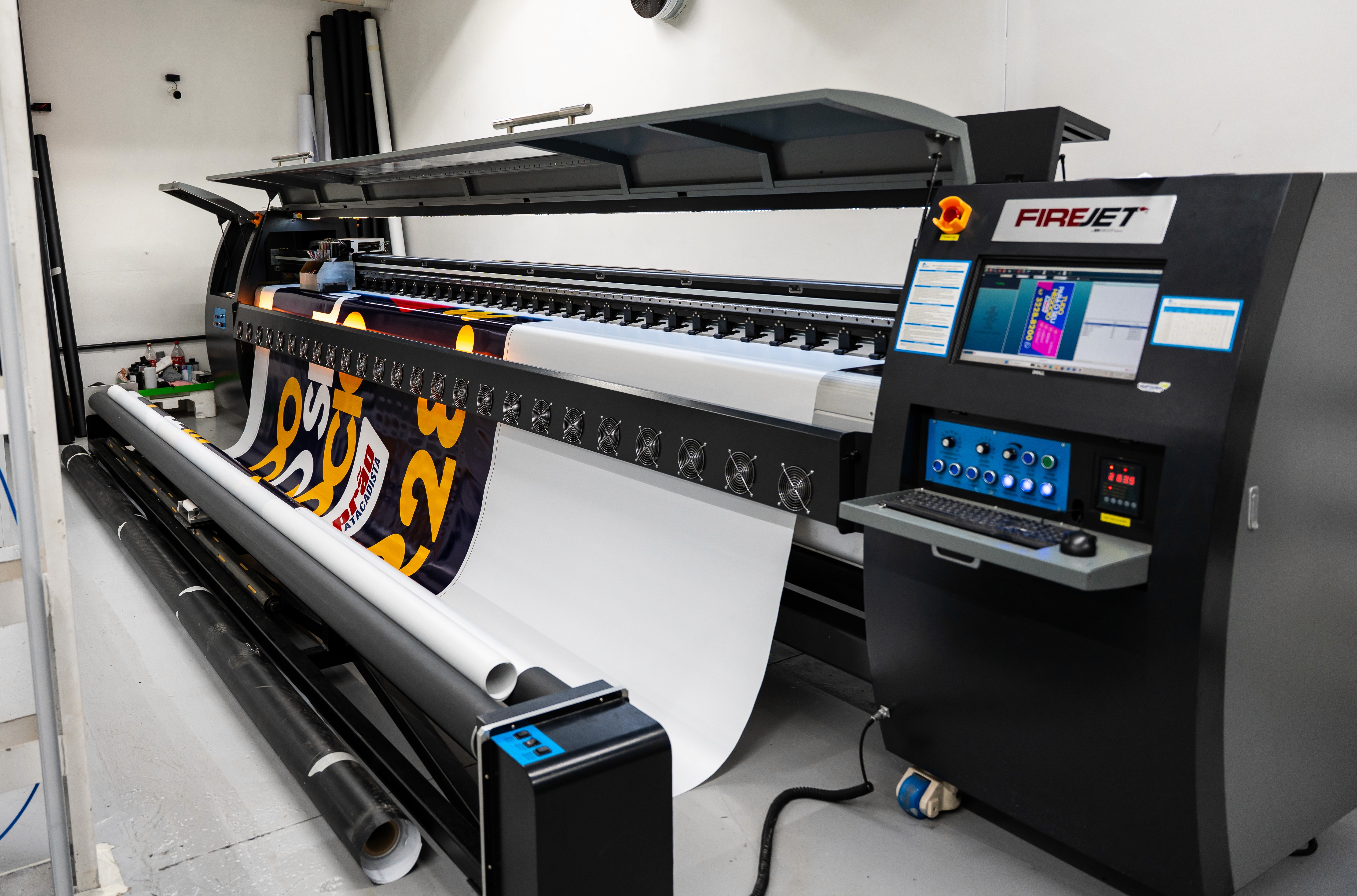 A large group photo of diverse team members gathered in an industrial-style space with arched ceiling.