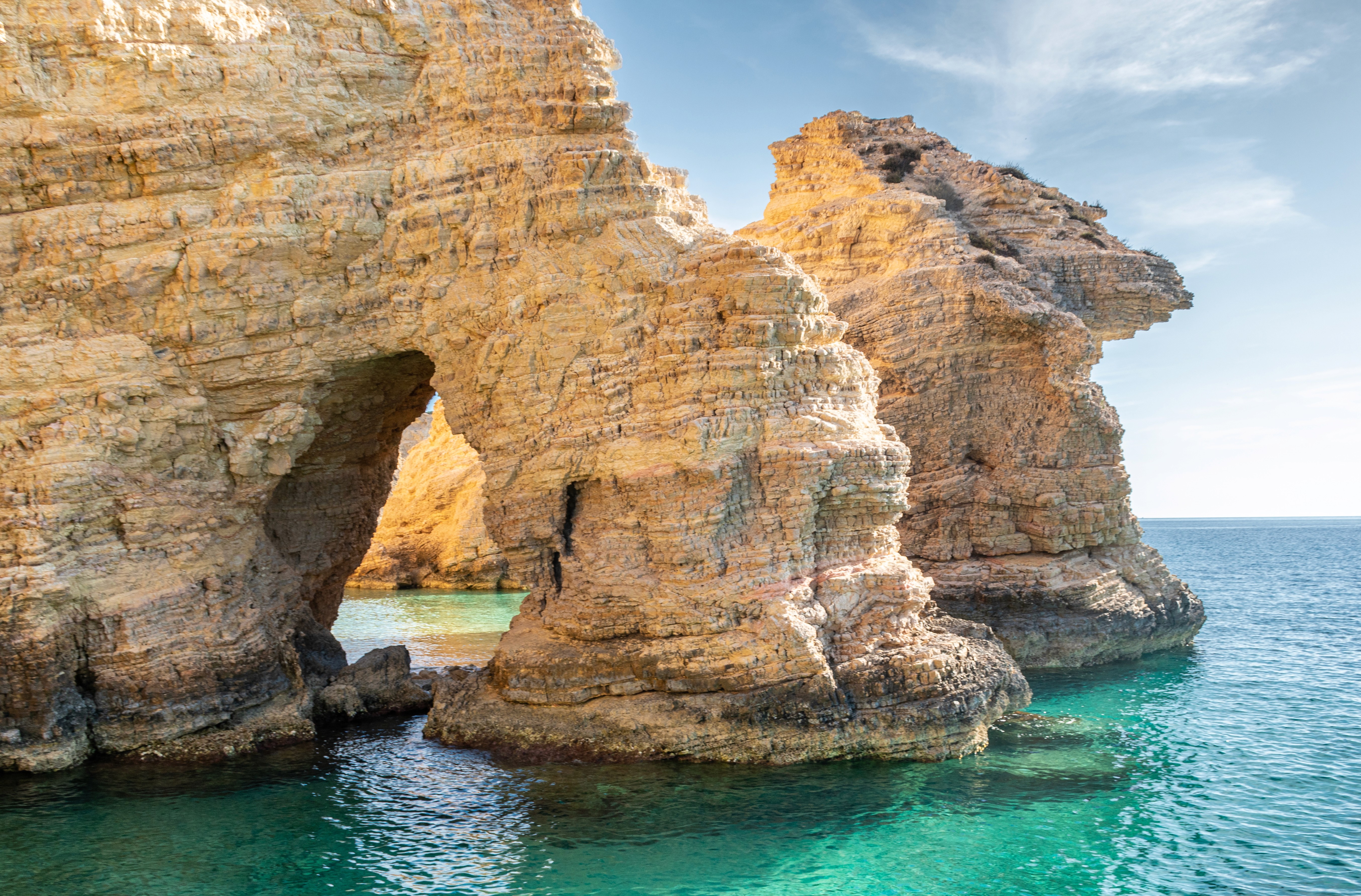 An underpass of rocks flowing into the ocean