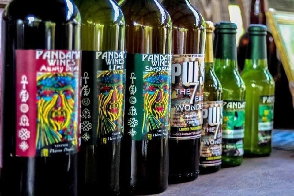 Close-up of wine bottles featuring colorful, artistic labels with faces.