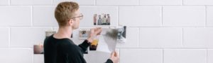 A man putting pictures on the wall