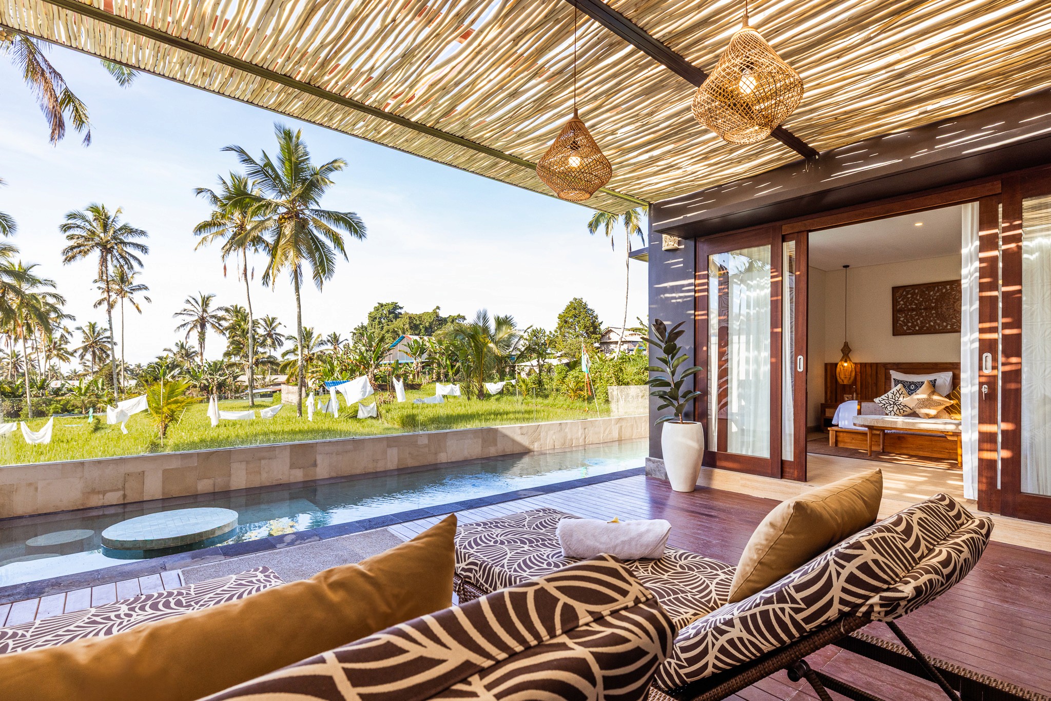 Offene Terrasse mit Blick auf Palmen und Reisfelder – Tropisches Wohnen in den Khastana Hadi Luxury Villas, Bali
