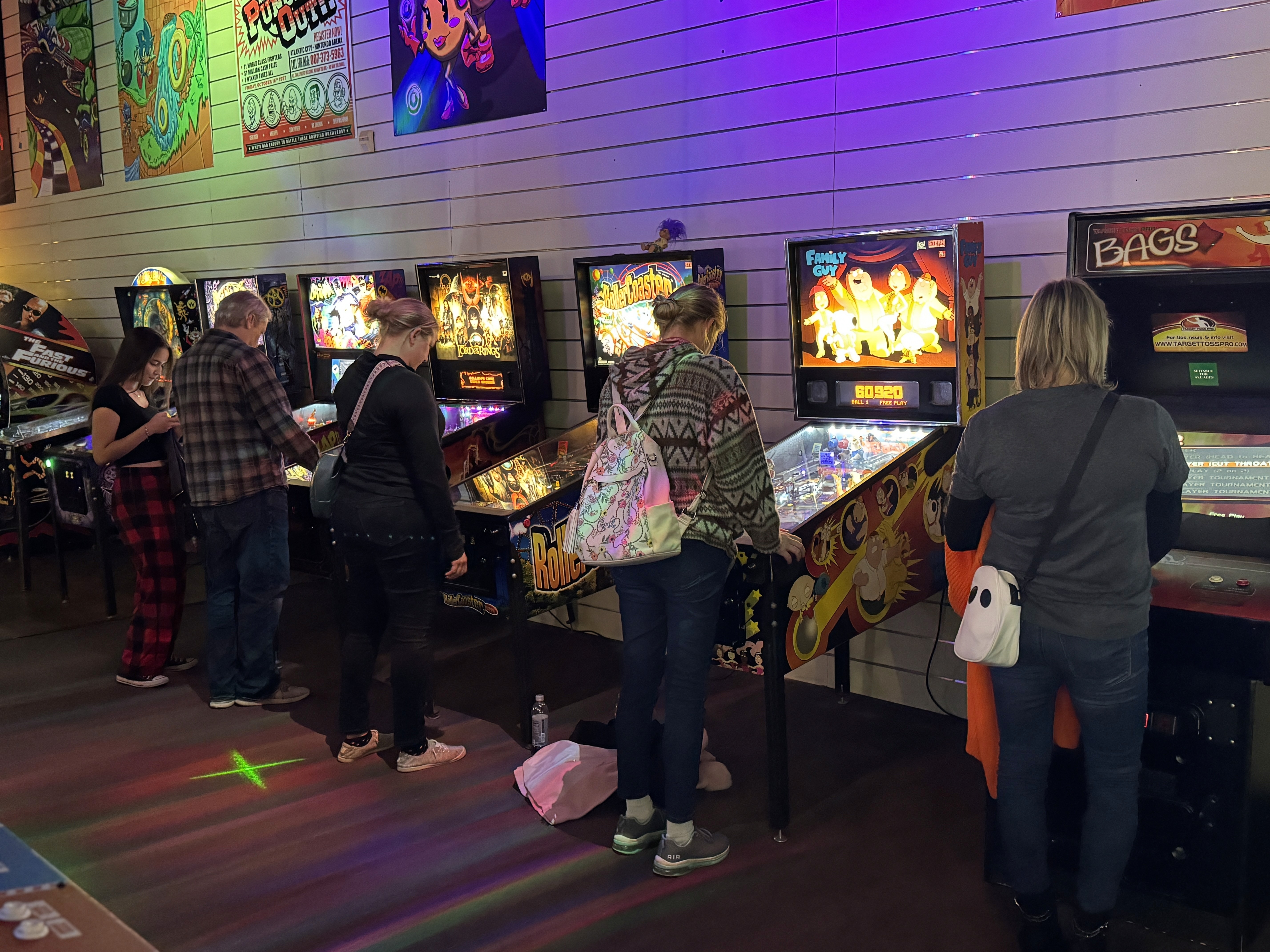 People playing pinball machines at The Old School Arcade in Rochester, MN