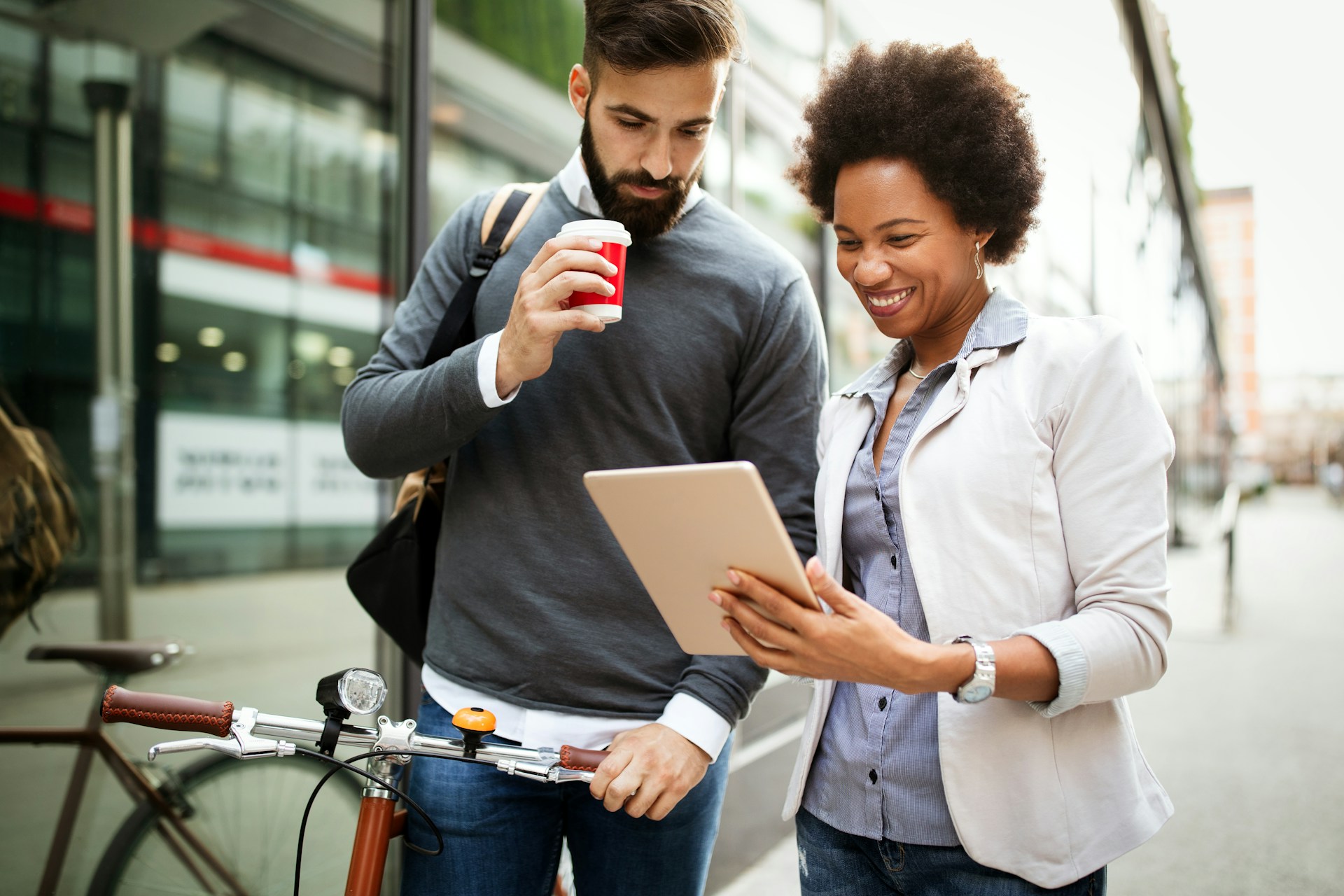Two person talking to each other while holding a tablet