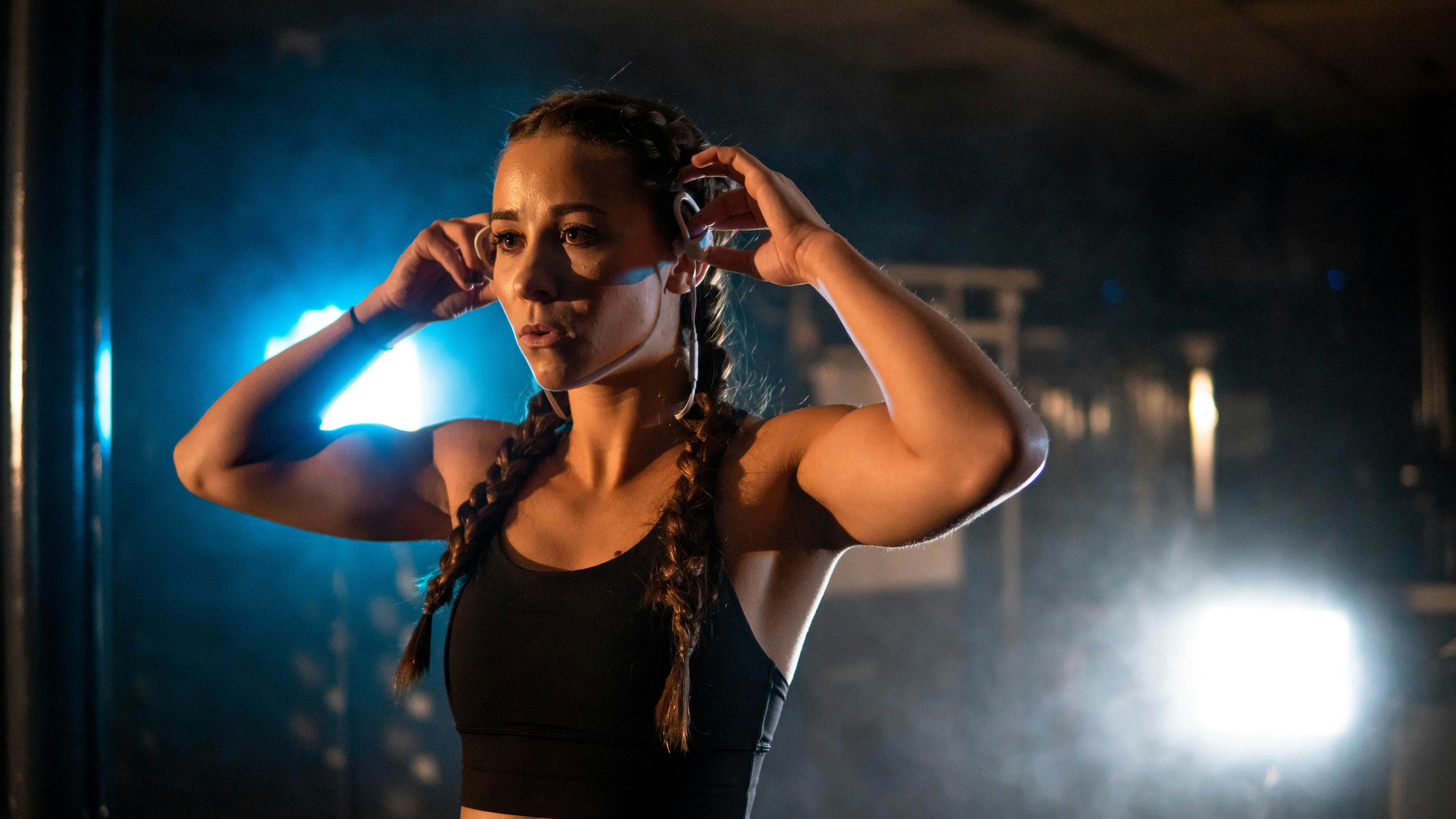 a woman in a black top is holding her hair