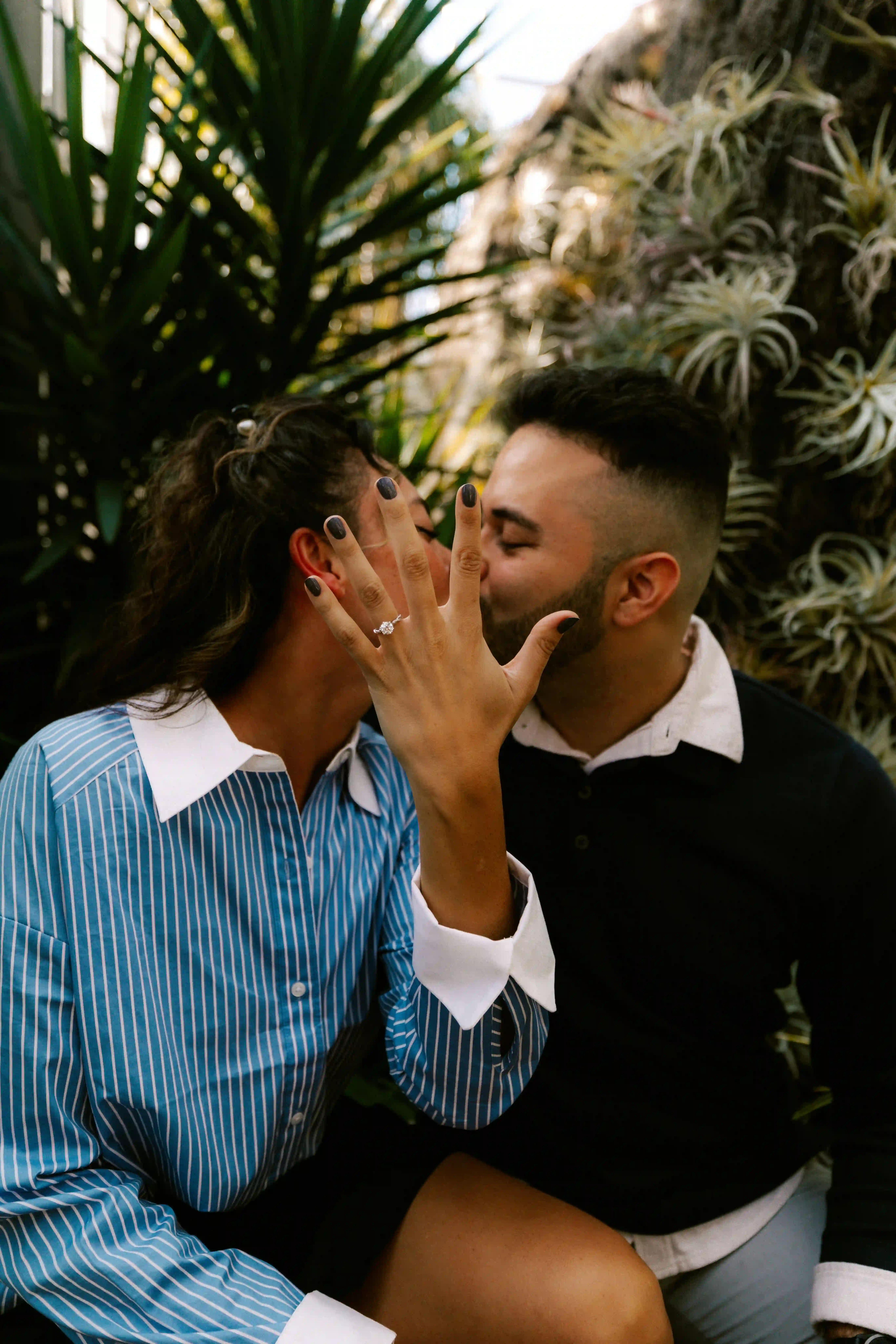 Couple kissing, showing engagement ring
