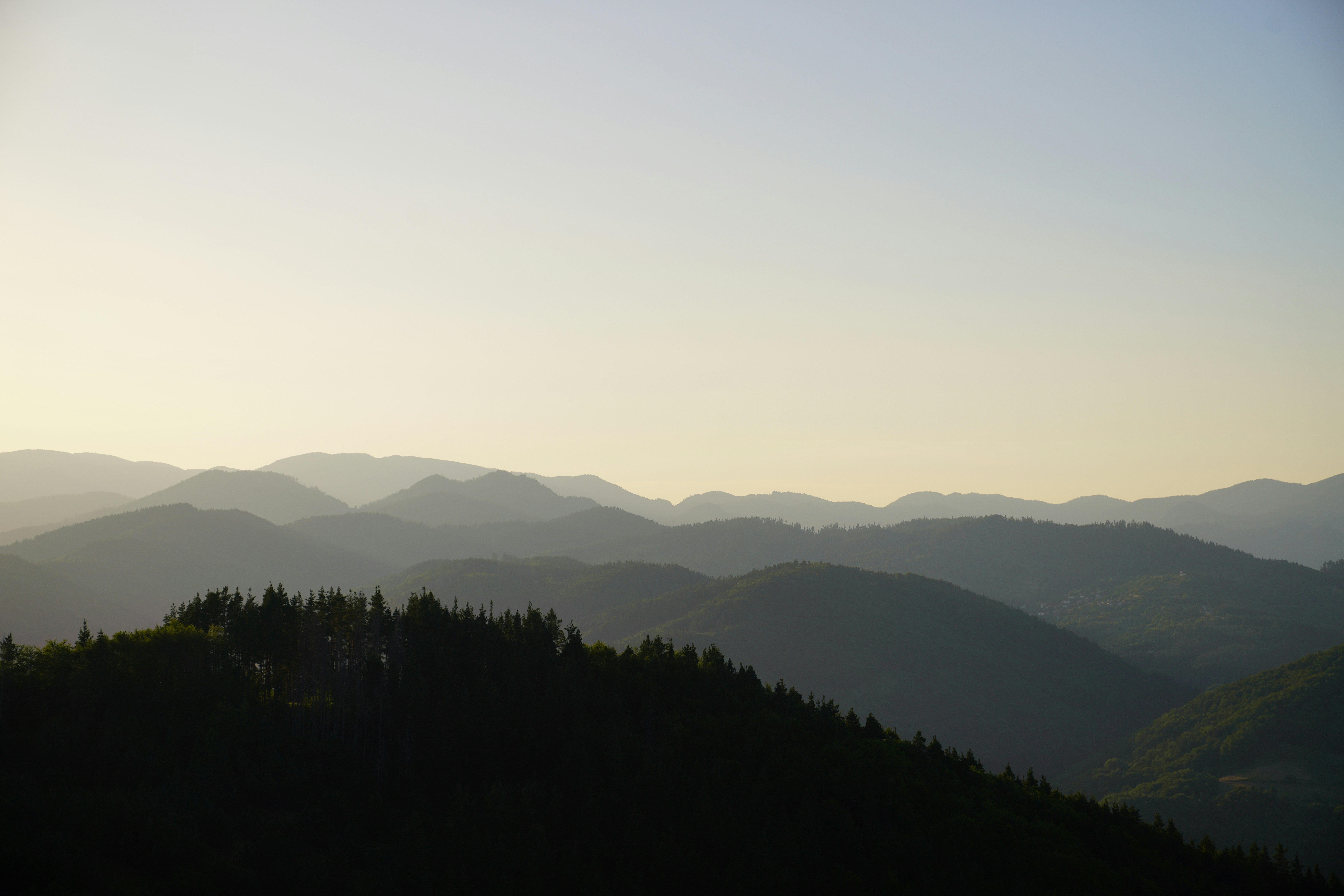 a view of a mountain range with trees in the foreground