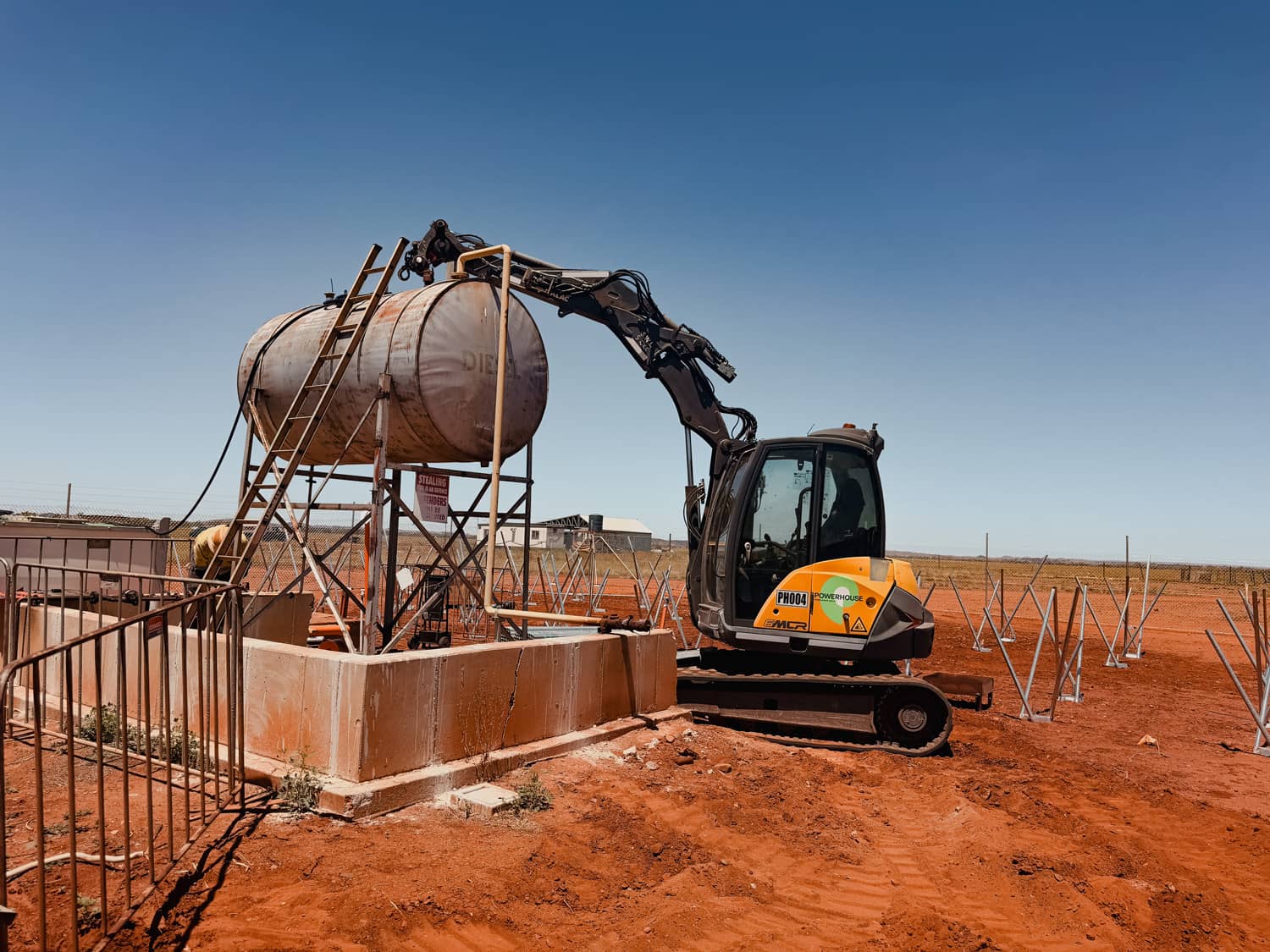Powerhouse PH004 excavator next to a diesel tank and scaffolding at a remote Australian industrial site.