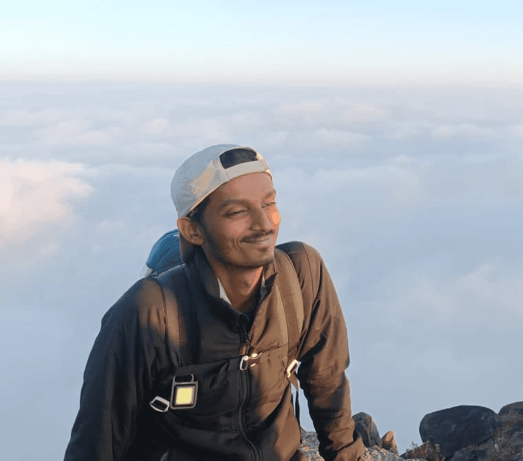 Portrait of a person in a pink sweater against a light background