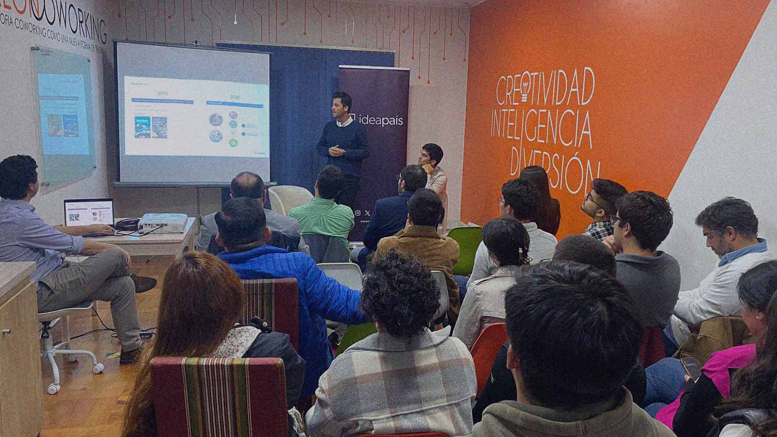 Foto de un grupo de personas en una sala mientras escuchan la presentación del director ejecutivo de IdeaPaís, Cristián Stewart.