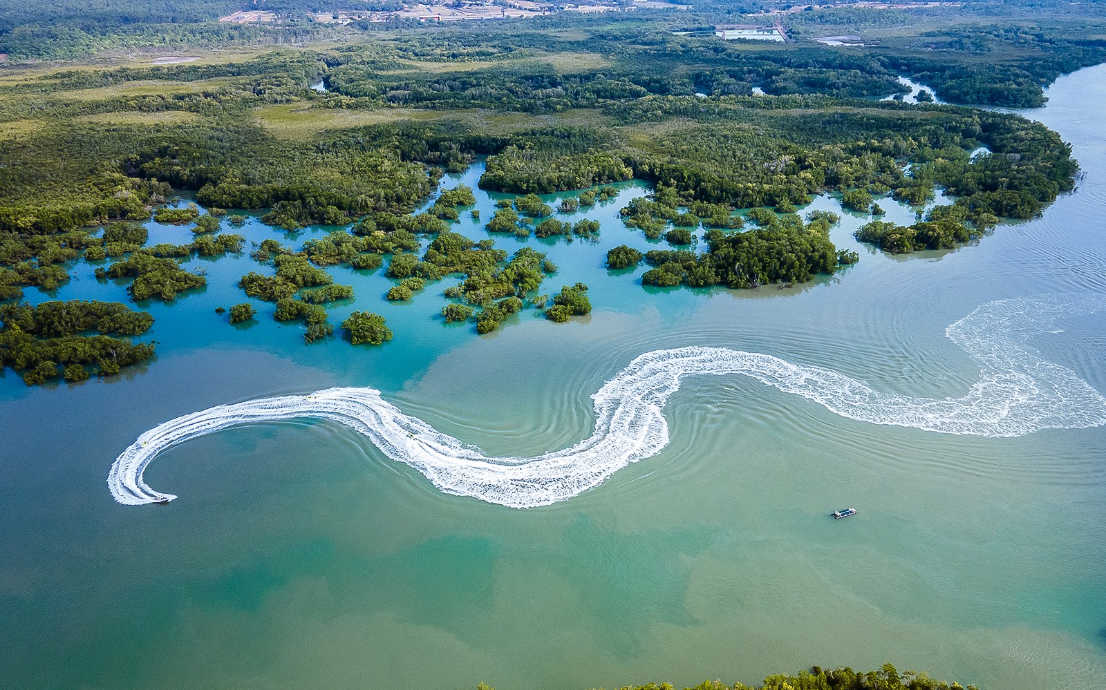 Jet ski creating wake trails in mangrove waters, Darwin.