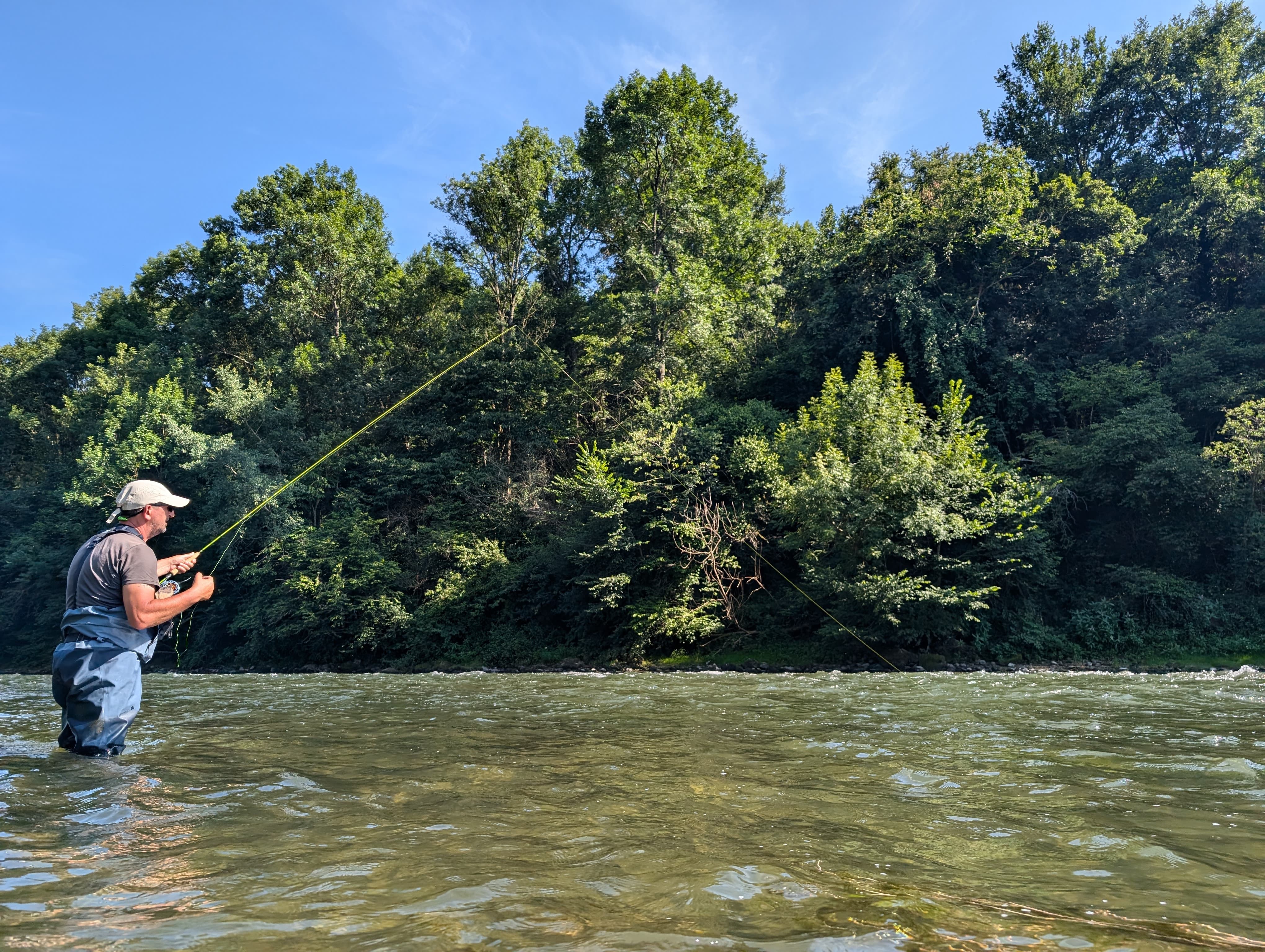 Challenging fishing in the Pyrenees: an angler preparing their gear for wild trout in a beautiful mountain setting.