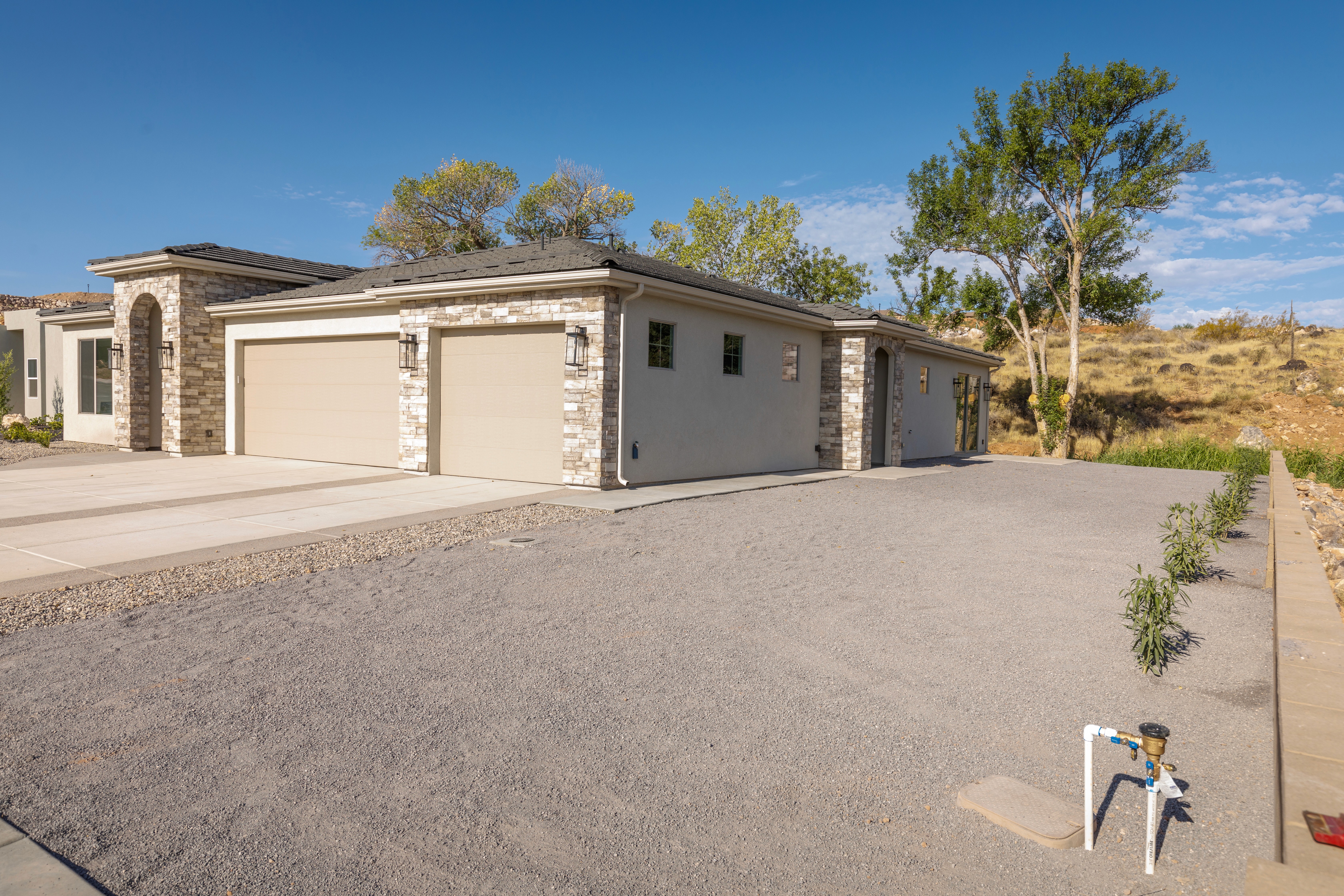 Side and front exterior of Mountain View’s Cove highlighting windows, rooflines, and inviting residential design  in a Hurricane, Utah home..