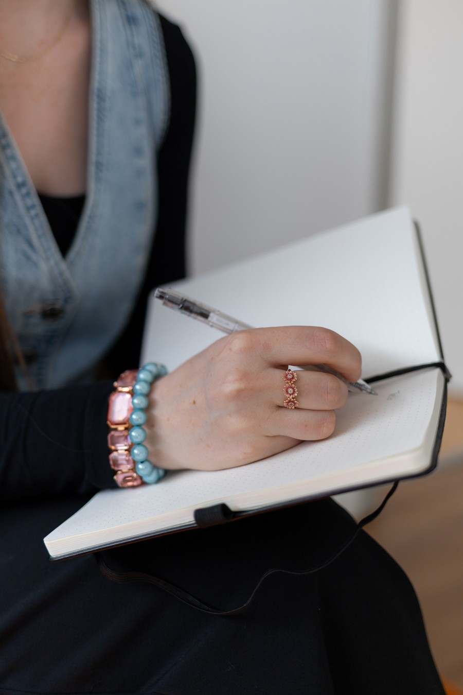 Nahaufnahme einer Hand, die einen Stift hält und in ein Notizbuch schreibt.