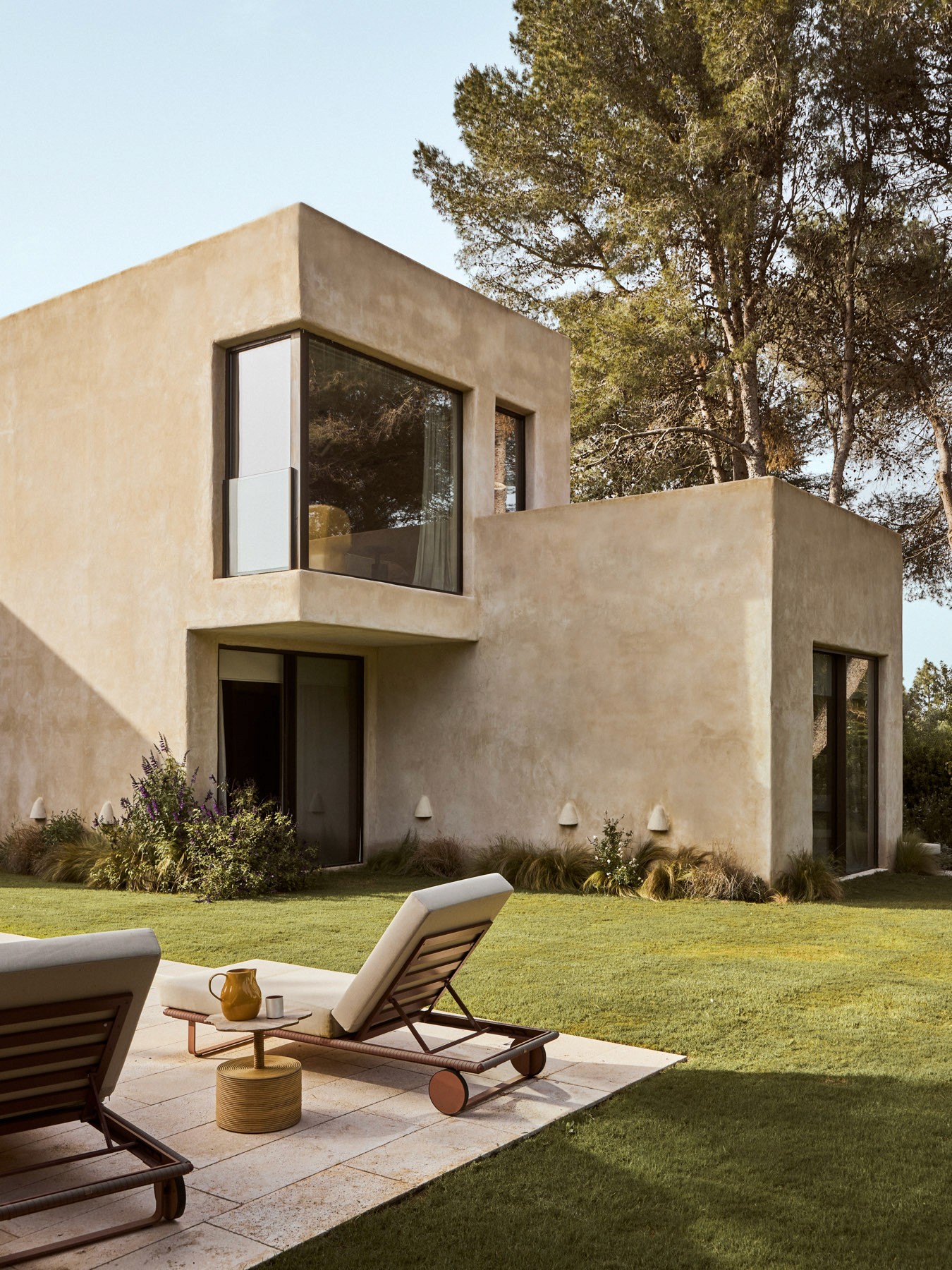 Exterior corner view of the residence featuring textured stucco walls and landscaped gardens.