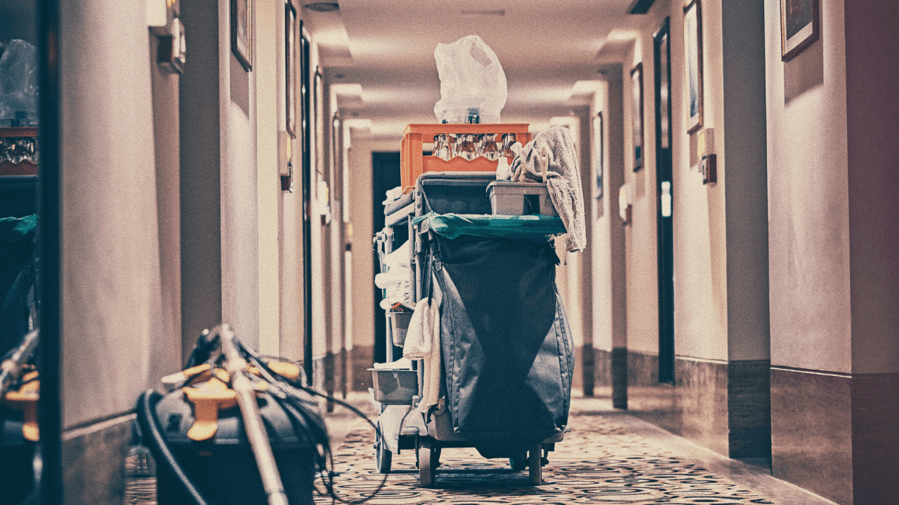 A cleaning cart filled with supplies in a hotel hallway, symbolizing the hard work and dedication of cleaning staff, and how flexible payroll solutions like real-time pay can support their needs.