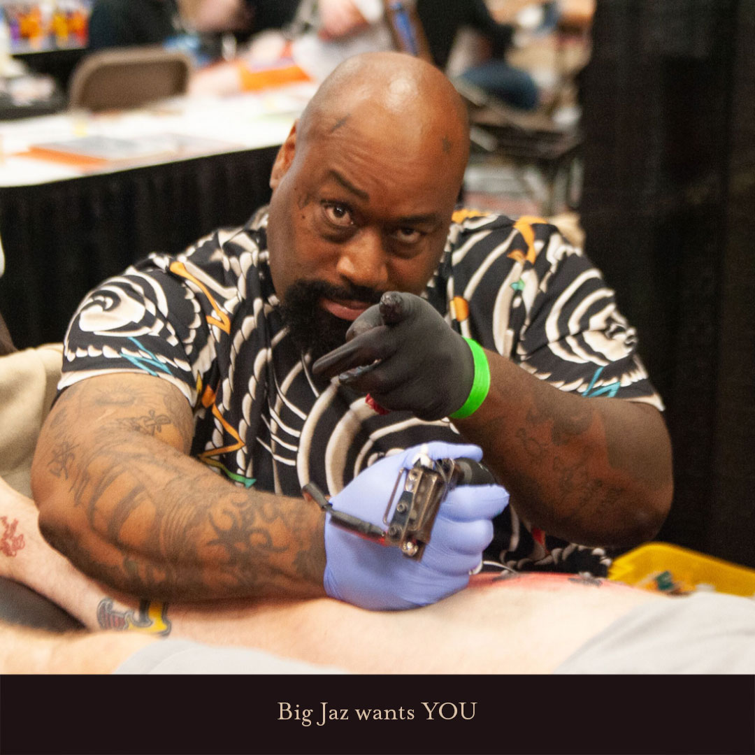 Big Jaz pointing at the camera and tattooing during the Richmond Tattoo and Arts Convention