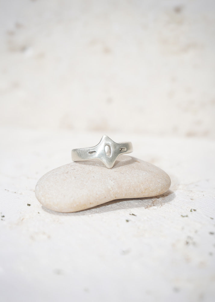 Silver ring on a white stone with a blurred white background