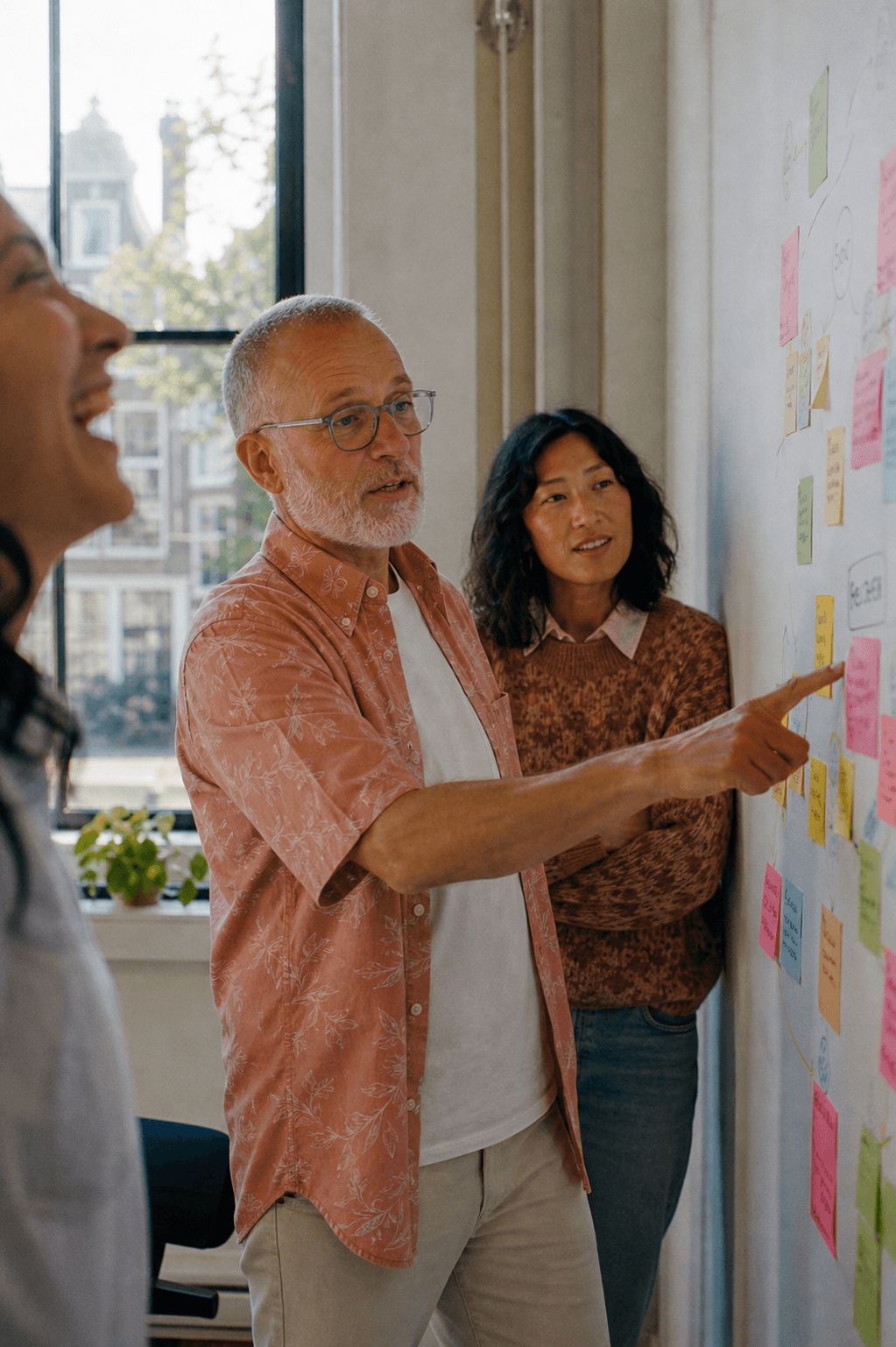 Facilitator presenting back at the sticky-note wall, colleagues listening
