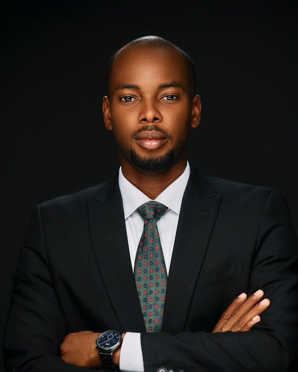 Editorial portrait of a young man with wavy hair in a knit sweater, looking over his shoulder in soft light.
