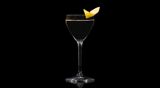 A closeup of a Vodka Martini drink against a dark background.